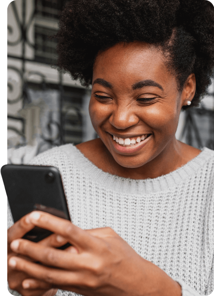 An image of a woman smiling and pressing her phone